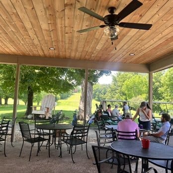 Outdoor patio dining area of Urban Grille under trees