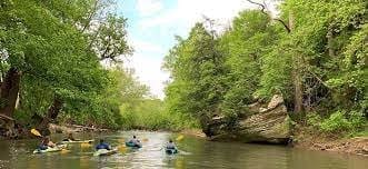 Kayakers on the Hocking River surrounded by lush greenery