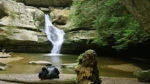 Cascading waterfall surrounded by mossy rocks at Cedar Falls in Hocking Hills