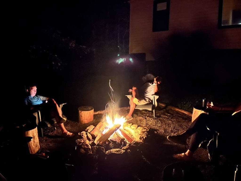 Group gathered around an outdoor fire pit on an autumn evening in Hocking Hills